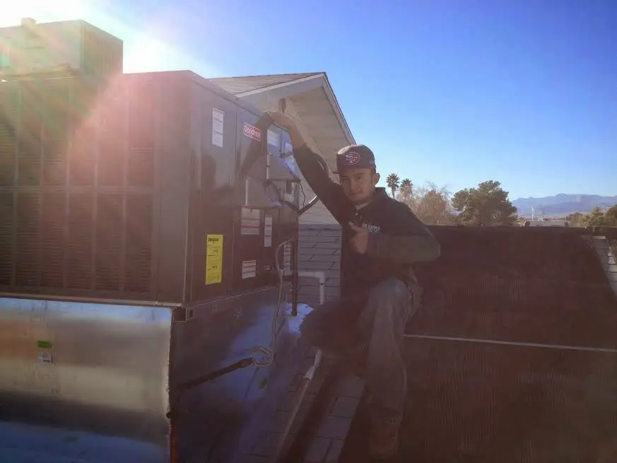 HVAC technician performing AC Tune-Up on a rooftop unit in Uvalde